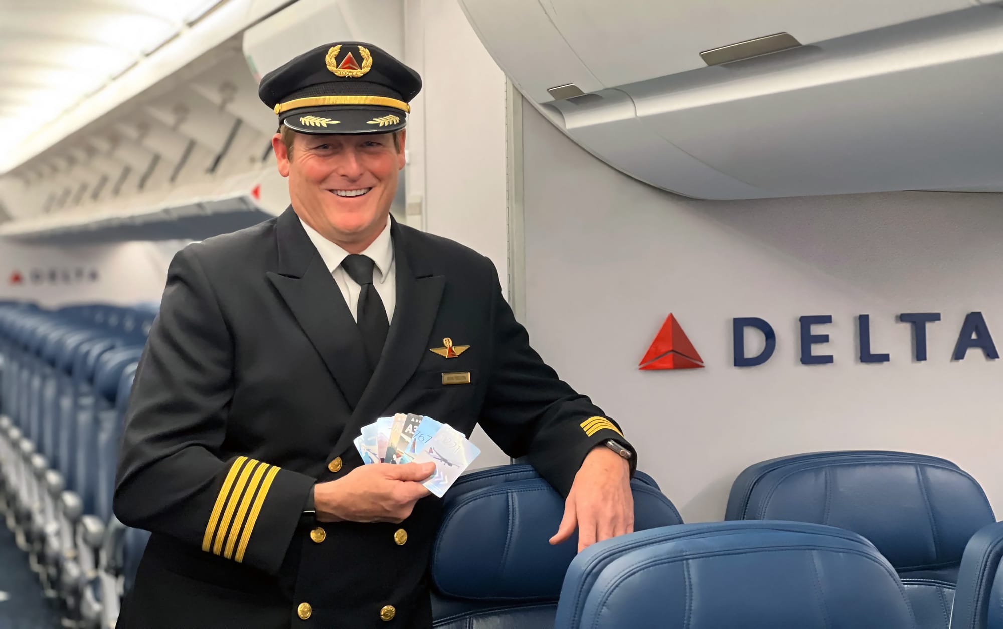 Delta piloot Brian Ferguson met een handje vol Delta trading cards.